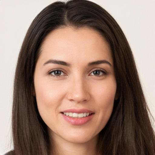 Joyful white young-adult female with long  brown hair and brown eyes