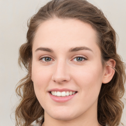 Joyful white young-adult female with medium  brown hair and blue eyes