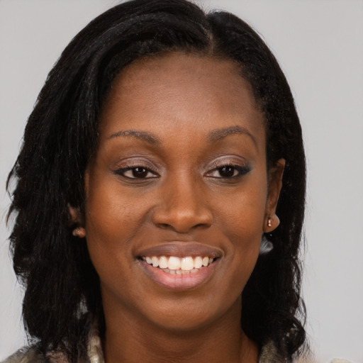 Joyful black young-adult female with long  brown hair and brown eyes