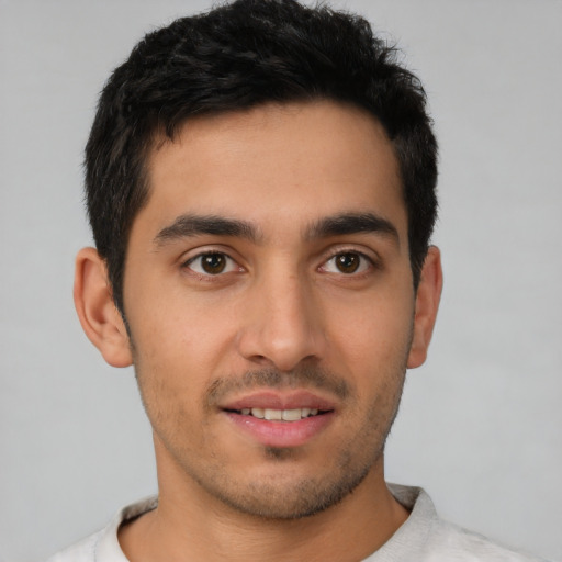 Joyful latino young-adult male with short  black hair and brown eyes