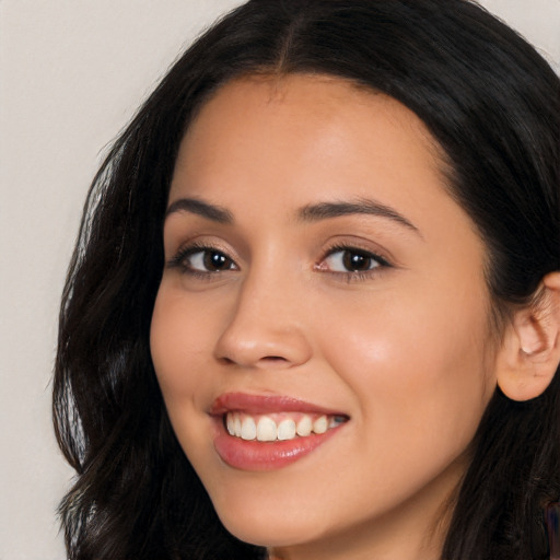 Joyful latino young-adult female with long  black hair and brown eyes