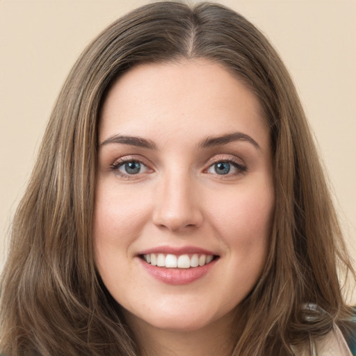 Joyful white young-adult female with long  brown hair and green eyes