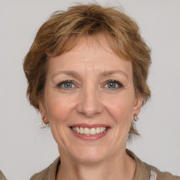 Joyful white adult female with medium  brown hair and grey eyes