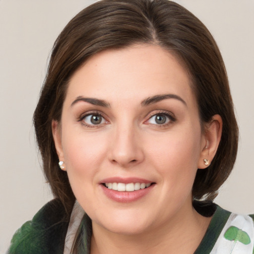 Joyful white young-adult female with medium  brown hair and green eyes