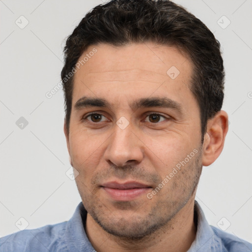 Joyful white young-adult male with short  black hair and brown eyes