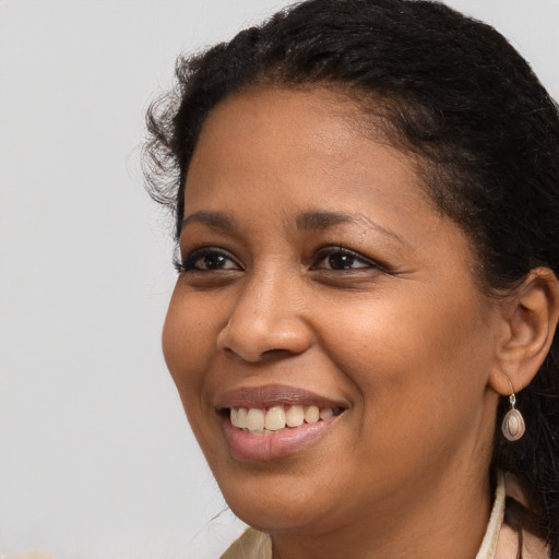 Joyful black young-adult female with long  brown hair and brown eyes