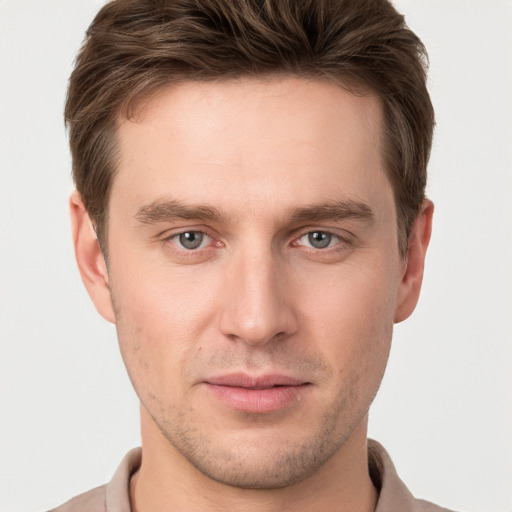 Joyful white young-adult male with short  brown hair and grey eyes