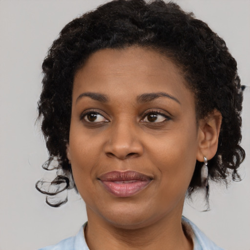 Joyful black young-adult female with medium  brown hair and brown eyes
