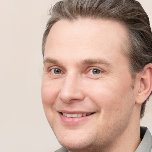 Joyful white adult male with short  brown hair and grey eyes