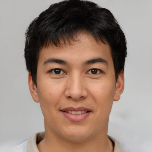 Joyful asian young-adult male with short  brown hair and brown eyes