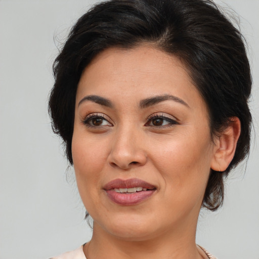 Joyful latino adult female with medium  brown hair and brown eyes