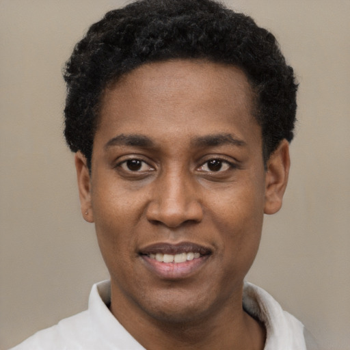 Joyful black young-adult male with short  black hair and brown eyes