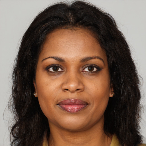 Joyful black young-adult female with long  brown hair and brown eyes