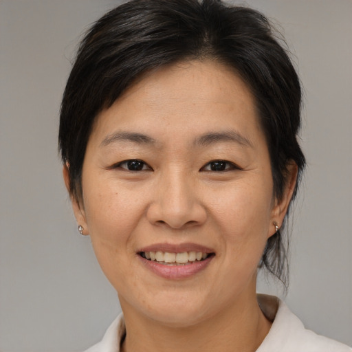 Joyful asian adult female with medium  brown hair and brown eyes