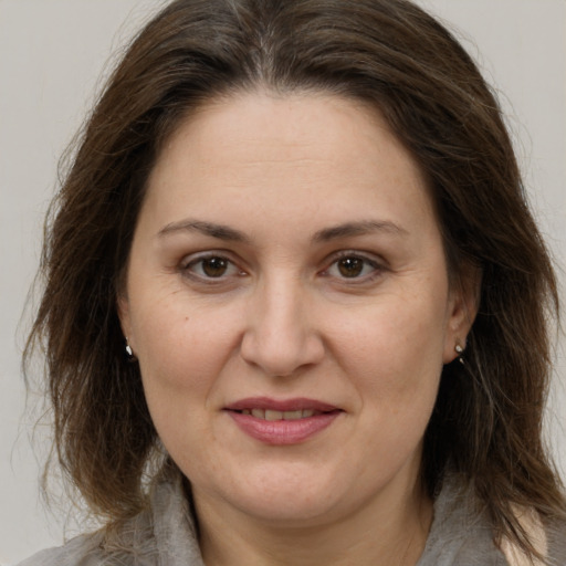 Joyful white adult female with medium  brown hair and brown eyes