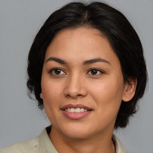 Joyful latino adult female with medium  brown hair and brown eyes