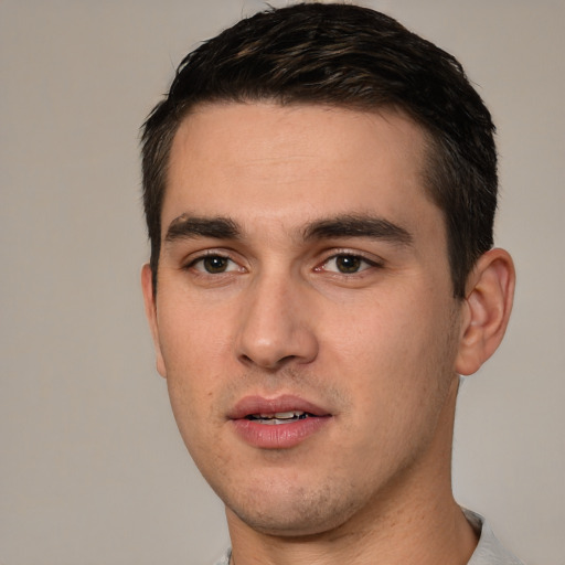 Joyful white young-adult male with short  black hair and brown eyes