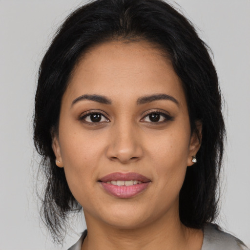 Joyful latino young-adult female with medium  brown hair and brown eyes