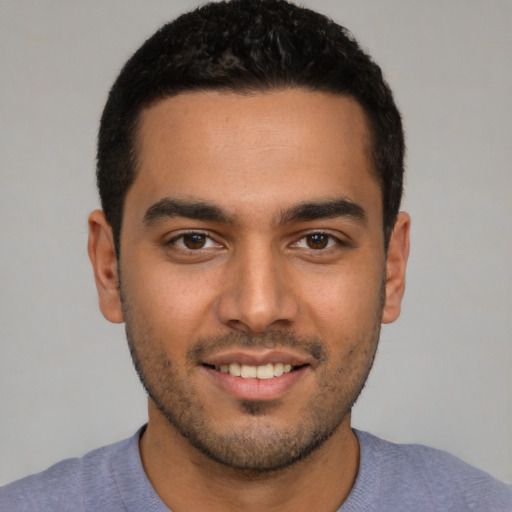 Joyful latino young-adult male with short  brown hair and brown eyes
