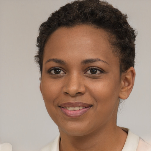 Joyful black young-adult female with short  brown hair and brown eyes