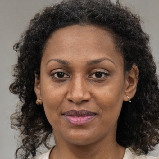 Joyful black adult female with medium  brown hair and brown eyes