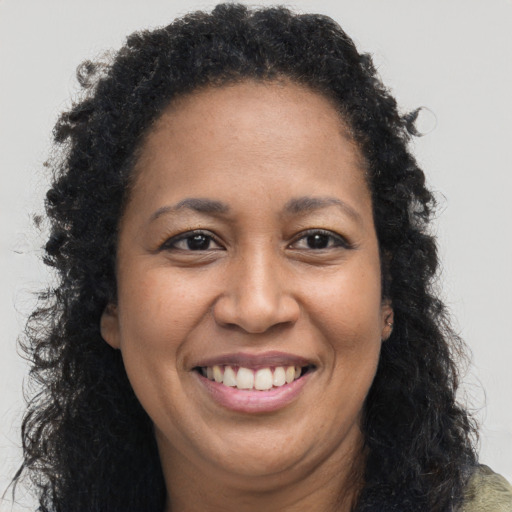 Joyful black adult female with long  brown hair and brown eyes