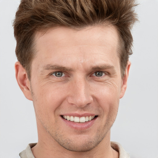 Joyful white adult male with short  brown hair and grey eyes