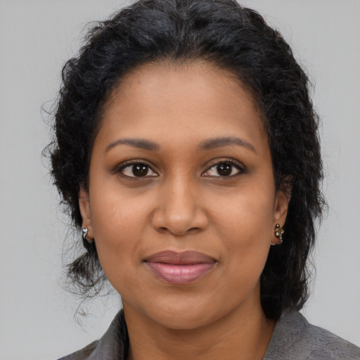 Joyful black young-adult female with medium  brown hair and brown eyes