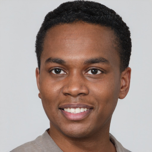 Joyful black young-adult male with short  black hair and brown eyes