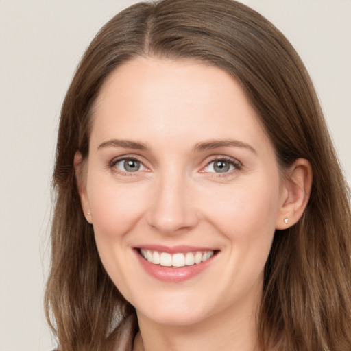 Joyful white young-adult female with long  brown hair and brown eyes