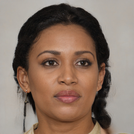 Joyful black adult female with medium  brown hair and brown eyes
