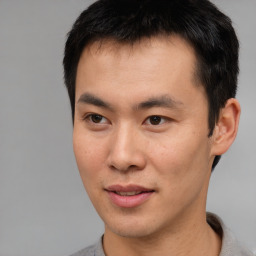 Joyful asian young-adult male with short  brown hair and brown eyes