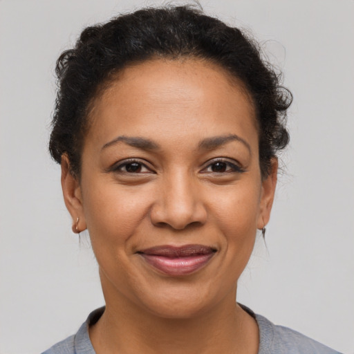 Joyful latino adult female with short  brown hair and brown eyes