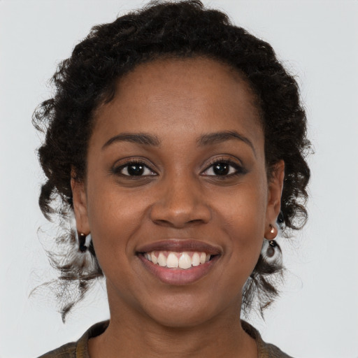 Joyful black young-adult female with medium  brown hair and brown eyes