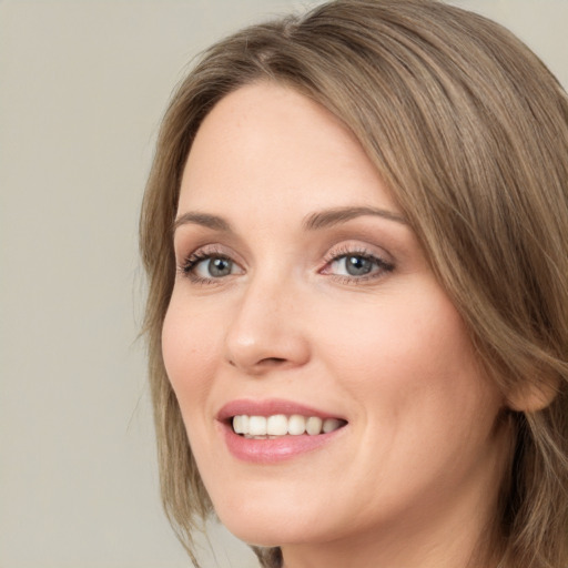 Joyful white young-adult female with medium  brown hair and green eyes