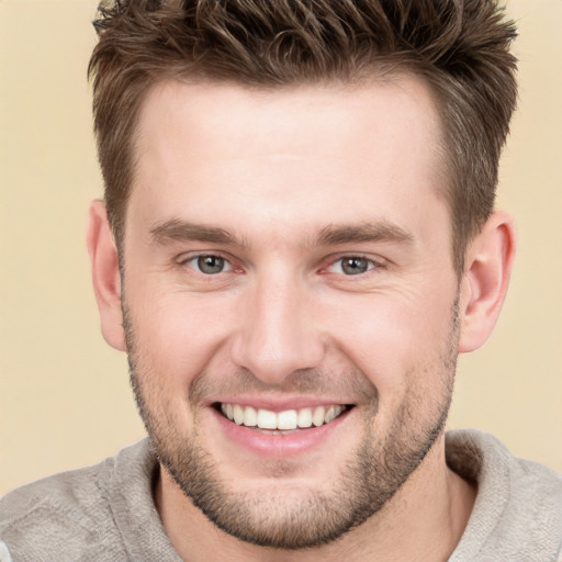 Joyful white young-adult male with short  brown hair and grey eyes