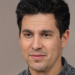 Joyful white adult male with short  black hair and brown eyes