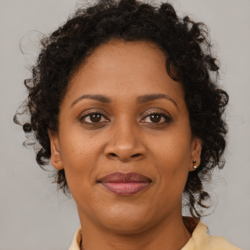 Joyful black adult female with medium  brown hair and brown eyes