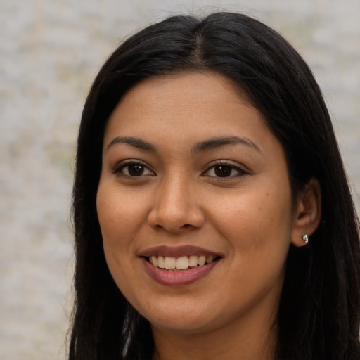 Joyful latino young-adult female with long  brown hair and brown eyes