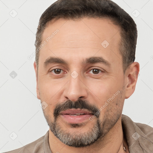 Joyful white adult male with short  brown hair and brown eyes