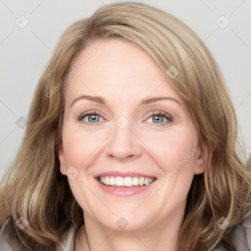 Joyful white adult female with long  brown hair and blue eyes