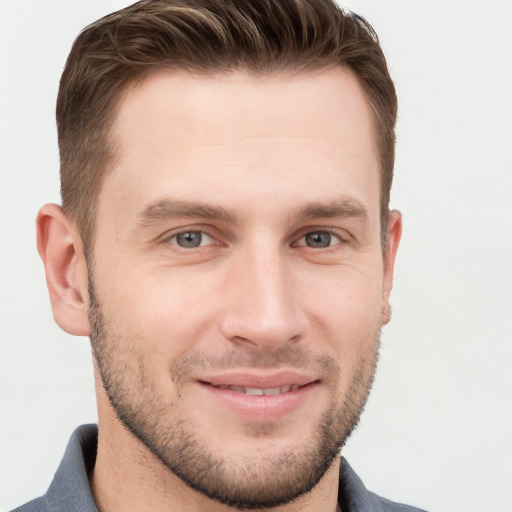 Joyful white young-adult male with short  brown hair and grey eyes