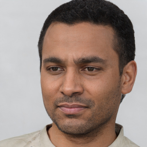 Joyful latino young-adult male with short  black hair and brown eyes