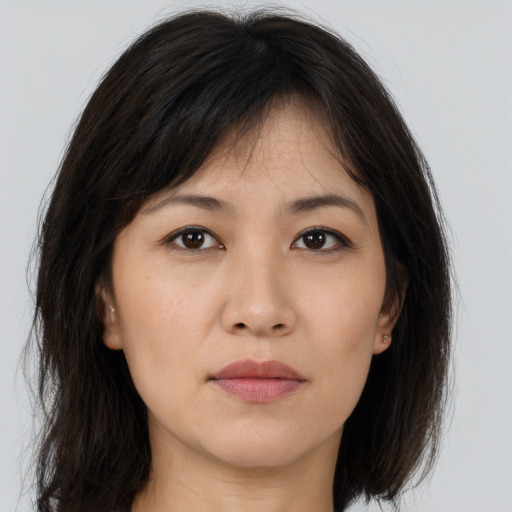 Joyful asian young-adult female with long  brown hair and brown eyes
