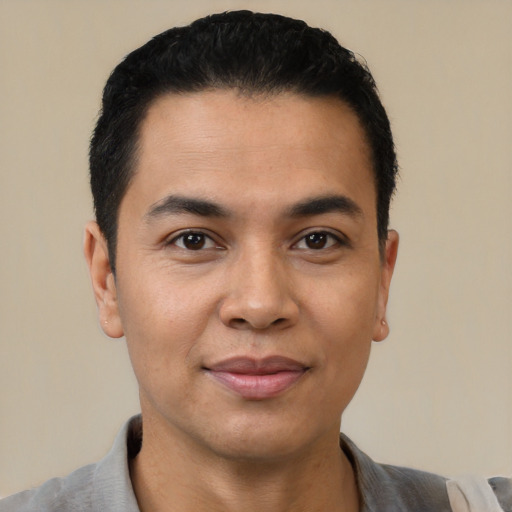 Joyful latino young-adult male with short  black hair and brown eyes