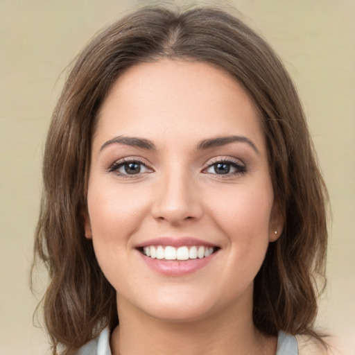 Joyful white young-adult female with medium  brown hair and green eyes