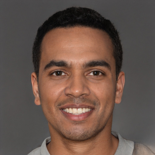 Joyful latino young-adult male with short  black hair and brown eyes