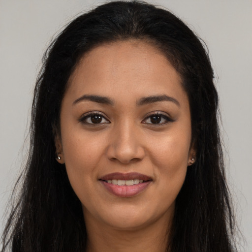 Joyful latino young-adult female with long  brown hair and brown eyes