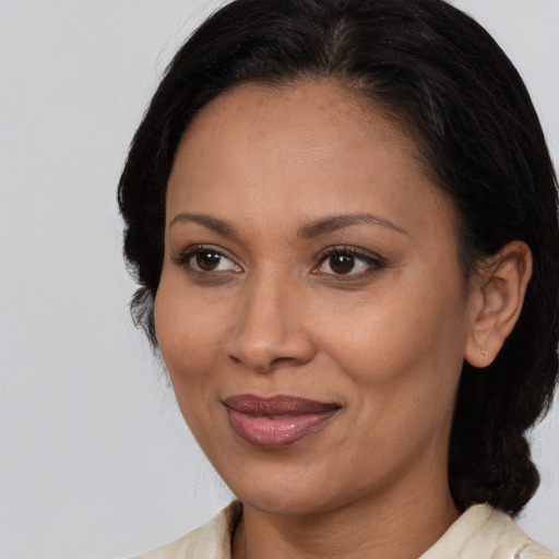 Joyful latino adult female with medium  brown hair and brown eyes