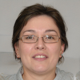 Joyful white adult female with medium  brown hair and blue eyes